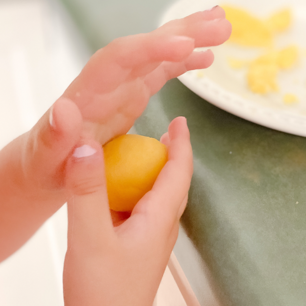 Cake pop dough being rolled between two hands.